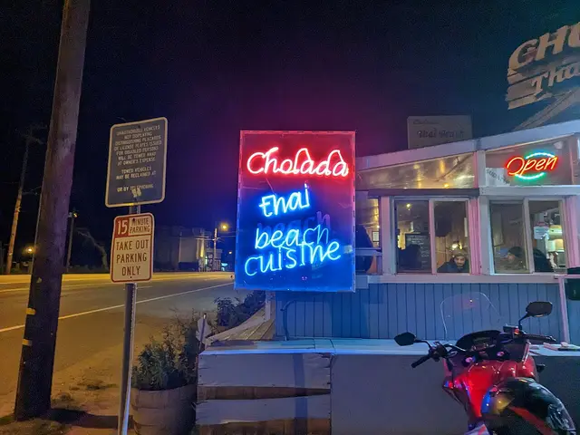 Evening exterior of a Thai restaurant with a lit sign.