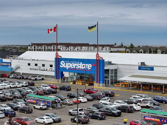 An aerial view of a Real Canadian Superstore exterior with its blue signage, flags, and a large parking lot