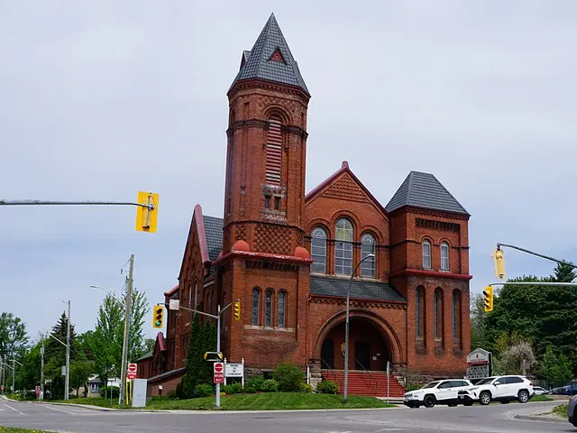 Dundas Street United Church in Woodstock, Ontario, a red brick church with a tall corner bell tower and steeple.