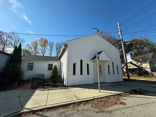 A white clapboard Church of God building with a cross on the roof peak