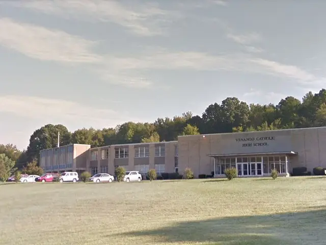 The exterior of Venango Catholic High School, a low brick building with its name lettered above the entrance.