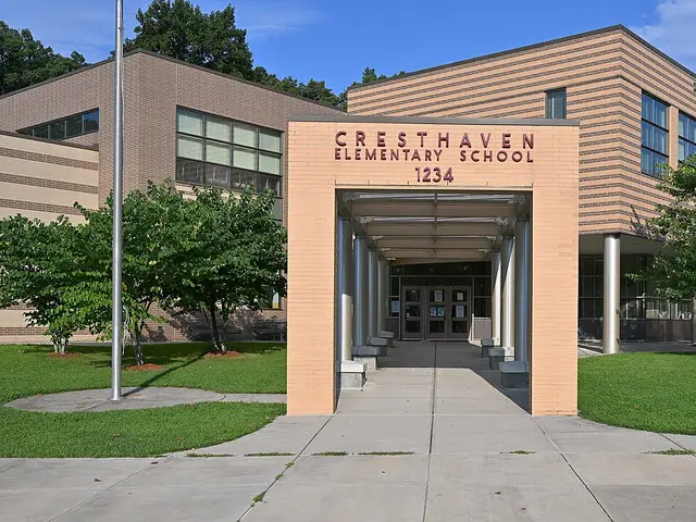 The covered entrance of Cresthaven Elementary School, with its name and address lettered above the walkway.