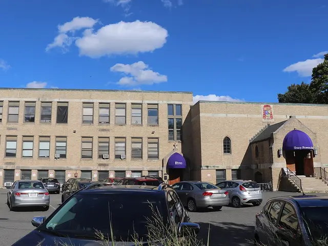 The brick exterior of Powers Music School, with a purple awning over its entrance.