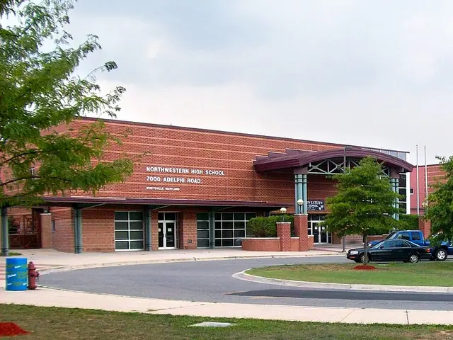 The brick exterior of a modern high school building with a parking lot in front, no people visible.