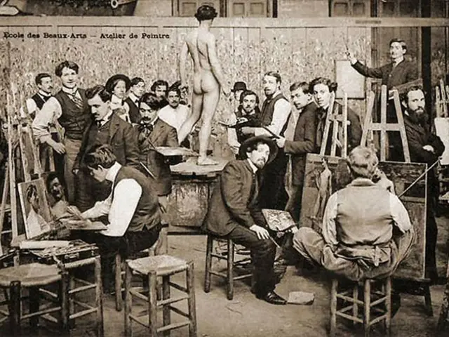 A historical photograph of adult art students painting at easels around a model in a painting workshop at the Ecole des Beaux-Arts.
