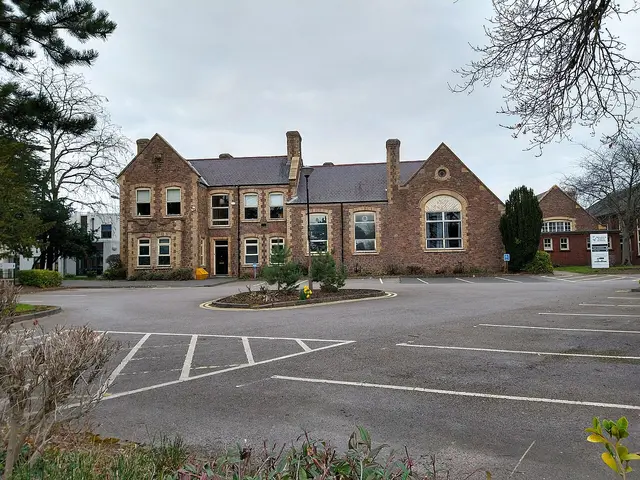 The brick front exterior of Rawlins Academy, a school building in Quorn, Leicestershire, UK.