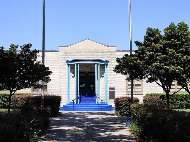 The front entrance of Looscan Elementary School in Houston, Texas, framed by trees.