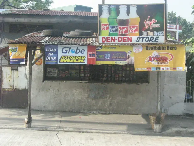 A small Filipino sari-sari store storefront with hanging advertising banners for mobile load and beverages